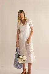 Vestido midi blanco con bordado inglés, escote en V, mangas cortas abullonadas con ajuste de lazo y falda acampanada.