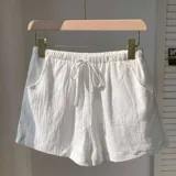 Short blanco de tela rústica con cintura elástica y cordón ajustable.