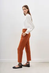 Pantalón de vestir color ladrillo, corte recto, con cintura elastizada y bolsillos laterales.