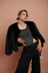 Body negro con escote redondo y apliques de strass plateados en el frente. Presenta corte cut-out en los laterales y cierre con lazos.