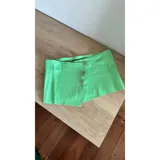 Top verde agua de cuero ovino con cierre de botones metálicos.