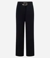 Pantalón de vestir color crudo, de corte recto, con bolsillos laterales y traseros. Se ajusta a la cintura con cinturón de cuero marrón con hebilla dorada.