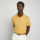 Remera amarilla de punto de piqué con cuello polo y mangas cortas.
