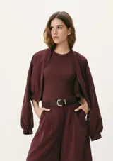 Blusa cropped color marrón de tela acanalada, con cuello redondo y mangas cortas.