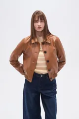 Chaqueta estilo bomber corta de eco-cuero color caramelo, con cuello camisa, cierre frontal de botones oscuros y puños y cintura de tejido acanalado.