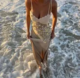 Top de punto color crudo con lentejuelas multicolores, tirantes finos y corte irregular.