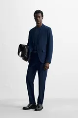 Pantalón de vestir negro slim fit, confeccionado en tejido con viscosa. Cuenta con bolsillos frontales y traseros de vivo. El cierre es frontal con cremallera y botón.