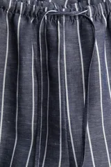 Pantalón recto de tela vaporosa a rayas verticales blancas sobre fondo gris. Tiene corte holgado, cintura elástica con cordón de ajuste, bolsillos laterales y traseros insertados.