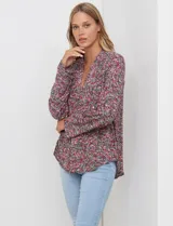 Blusa de manga larga con estampado floral pequeño en tonos rosados, morados y azules, escote en V y detalle de botones frontales.