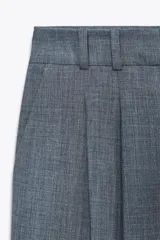 Pantalón de vestir azul con pinzas, tiro alto, corte ancho y trabillas.