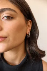 Aros de acero quirúrgico hipoalergénico con forma de argolla plateada y dije circular colgante de piedra natural color azul.