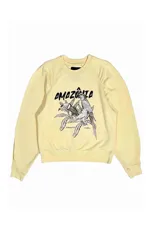 Buzo amarillo con estampado de un loro y plantas.