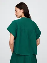 Camisa de muselina color blanco, con cuello mao y mangas cortas.