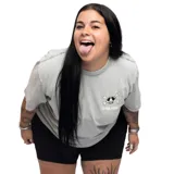 Remera gris de manga corta con cuello redondo y estampado pequeño en el pecho de una calavera con lentes de sol y el texto "La Vela Puerca".