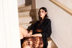 Vestido strapless largo con estampado batik en tonos marrones y beige, entallado al cuerpo y con espalda baja descubierta.