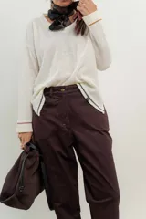 Sweater de punto gris con cuello en V y ribetes en contraste.