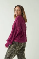 Sweater marrón de punto trenzado con cuello redondo y mangas largas abullonadas.