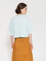 Remera gris con estampa de una mariquita y la palabra "Merci" en el frente.
