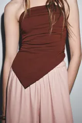 Top palabra de honor negro con escote recto, pliegues y bajo asimétrico.