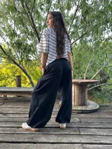 Blusa color beige de viscosa elastizada, con cuello bote y espalda cruzada. Estampado frontal con ilustración de una cara con corona de flores.