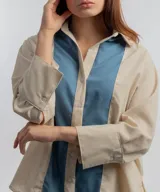 Camisa color beige con solapas y cierre con botones.