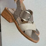 Sandalias negras de cuero con hebilla plateada y taco de madera.