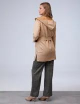 Chaqueta color beige de suede, marca Joan Vass. Cuello solapa, delantera con bolsillos. Cintura con pasadores y lazo de ajuste.
