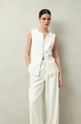 Pantalón sastrero ancho color crema con finas rayas verticales, de cintura alta con pinzas.