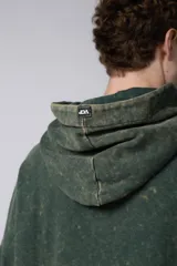 Buzo canguro verde con efecto desgastado, capucha con cordón ajustable, bolsillo frontal y puños con orificio para el pulgar.