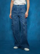 Pantalón de jean de tiro alto, color azul medio, con corte ancho y pierna recta. Presenta costuras marcadas en el centro de las piernas y bolsillos cargo a los lados.