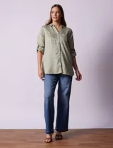 Camisa verde claro de tencel, marca Hester & Orchand. Cuello con solapa, escote en V y abertura central con botones. Delantera con bolsillos. Largo de manga regulable con presilla y botón.