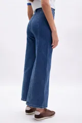 Pantalón de jean azul oscuro, corte ancho (wide leg), con costura frontal marcada en ambas piernas.
