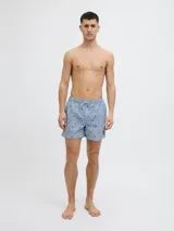 Short de baño celeste con rayas verticales blancas y estampado de motivos marinos en azul. Cuenta con cintura elástica ajustable con cordón y bolsillos laterales.