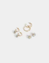 Set de tres pares de aros para mujer. Incluye un par de aros pasantes con forma de flor, un par de argollas con dije de flor y un par de argollas lisas.