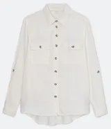 Camisa blanca de manga larga con cuello camisero, cierre frontal con botones a tono, dos bolsillos con solapa en el pecho y puños con trabilla.