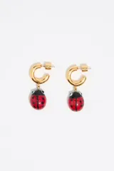 Par de aros colgantes con forma de aro dorado, con dije de mariquita roja con detalles en negro.