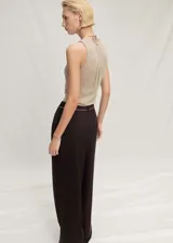 Top color beige de tejido de punto fino, cuello redondo y sin mangas.