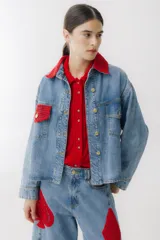 Campera de jean celeste con detalles de crochet rojo en cuello, bolsillo y ruedo. Tiene cierre frontal con botones dorados, bolsillos laterales y corte holgado.