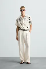 Camisa de manga corta con cuello bowling y estampado floral en tonos blanco y negro.