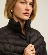 Campera puffer ultraligera color marrón, confeccionada en poliamida acolchada, con cuello alto y cierre por cremallera. Incluye bolsita con cordón.