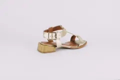 Sandalias de cuero doradas con tiras finas, suela plana y hebilla lateral.