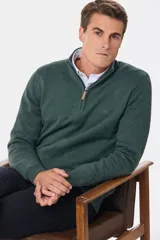 Sweater verde oscuro de tejido de punto con cuello alto y cierre metálico a mitad del frente.