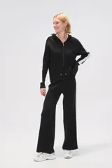 Campera negra de tejido de punto con capucha, cierre frontal y bolsillos tipo canguro. Presenta una franja blanca vertical en cada manga.