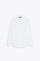 Camisa blanca de algodón con cuello solapa, manga larga con puños y cierre frontal con botones.