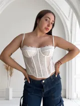 Corset blanco de encaje con tirantes finos y copas preformadas.