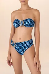 Top de bikini bandeau con estampado abstracto en tonos azules y negros. Presenta una hebilla dorada en el centro, breteles removibles y ajustables, y detalle de fruncido lateral.