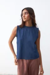 Musculosa de jean azul con volados en cuello y sisas.