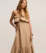 Vestido largo color beige, estilo evasé, confeccionado en tricolina de algodón. Presenta escote hombro a hombro con un volante superpuesto y bajo fruncido.