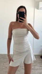 Vestido corto de lycra color amarillo pastel, sin mangas y con escote strapless.