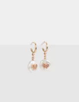 Aros dorados tipo argolla con dije de perla colgante y mariposa con strass rosados.